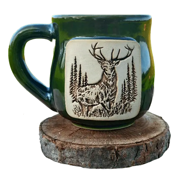 Green mug with applied ceramic picture of a deer, the mug is on a wooden base